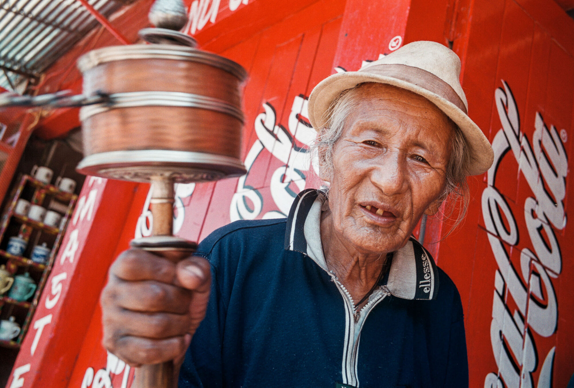 STG04: KATHMANDU, 16JUN00 - Der Westen gruesst den Osten. Coca Cola und andere Westprodukte ueberschwemmen den Ostmarkt. Rund um die Bouddhna Stupa in Kathmandu betet ein Glaeubiger Tibeter indem er seine Gebetsmuehlen kreisen laesst und immer wieder mal ein Schluck aus seiner Cola Flasche nippt.

da/ Photo by Daniel Ammann