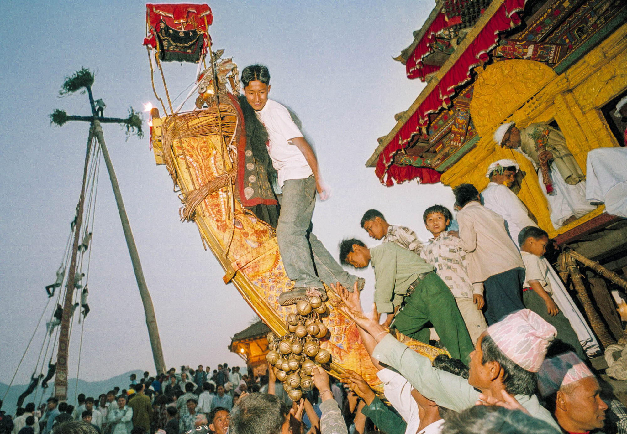 KATHMANDU 7. APRIL 2000 -  Einheimische in Nepals Stadt Bakthapur beginnen das Fest zum Jahreswechsel. Ein hoelzener Wagen wird geschoben und im Hintergrund erklimmen Jugendliche einen Lingam.

Photo by Daniel Ammann
