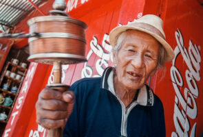 STG04: KATHMANDU, 16JUN00 - Der Westen gruesst den Osten. Coca Cola und andere Westprodukte ueberschwemmen den Ostmarkt. Rund um die Bouddhna Stupa in Kathmandu betet ein Glaeubiger Tibeter indem er seine Gebetsmuehlen kreisen laesst und immer wieder mal ein Schluck aus seiner Cola Flasche nippt.

da/ Photo by Daniel Ammann