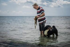 Dar Es Salaam, Tansania, 22. Juli 2014 - Werner Spitteler und sein Hund Blaess in Bagamoyo am Strand. Reportage in Tansania und Sansibar mit Werner Spitteler ueber Malaria, Artemisia Annua, Moringa und Mineralien.