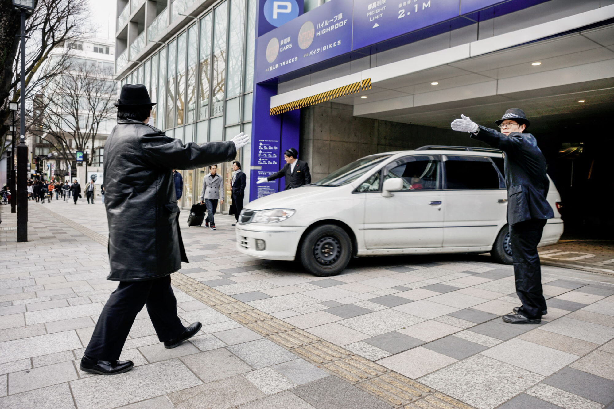 Tokio, Japan, 15. Februar 2009 - Tokio, Hauptstadt von Japan. Menschen auf der Strasse. Auto aus dem Parkhaus lotsen.

Photo by Daniel Ammann