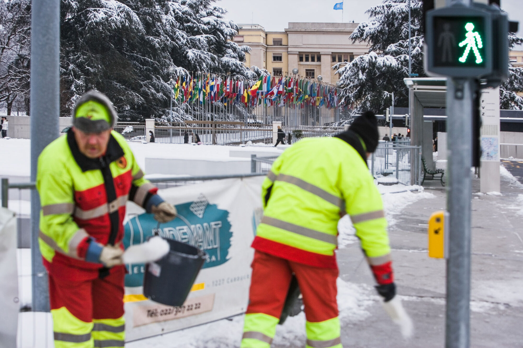 GENF, SCHWEIZ, 25. JANUAR 2007 - PALAIS DES NATION, UNO SITZ IN GENF. HAUPTEINGANG VOM PLATZ DES NATIONS, ZUM PORTAL NATIONS ZUR ALLEE DES NATIONS. STRASSENARBEITER STREUEN SALZ AUF DIE VEREISTEN TROTTOIRS.

FOTO BY DANIEL AMMANN